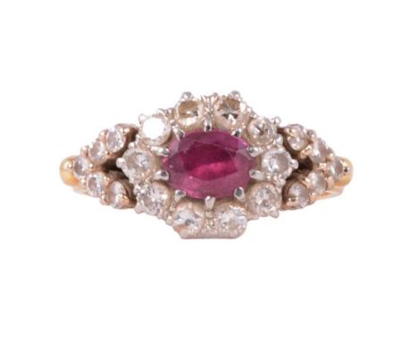 A ruby and diamond cluster ring, an oval mixed cut ruby claw set horizontally and surrounded by ten brilliant cut diamonds in