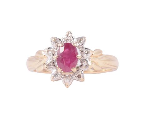 A ruby and diamond oval cluster ring, the oval faceted ruby claw set and surrounded by ten 8 cut diamonds in a 14 carat yello