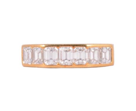 A diamond seven stone half hoop ring, the seven rectangular step cut stones channel set in an 18 carat yellow gold octagonal 