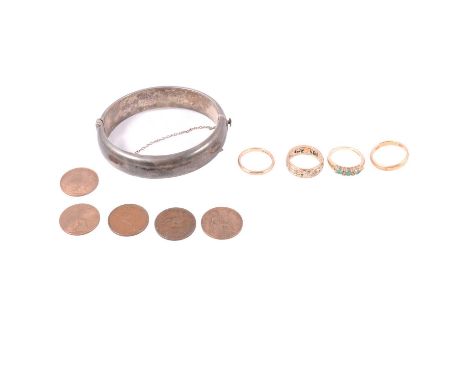 Four rings, silver half hinged bangle, coins and bank note, an emerald and diamond half hoop ring, the three brilliant cut em