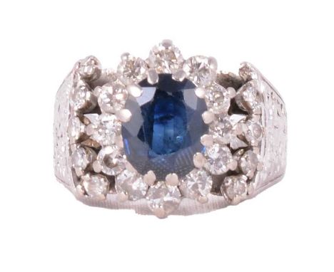 A vintage sapphire and diamond cluster ring, the oval mixed cut sapphire claw set and surrounded by twelve brilliant cut diam
