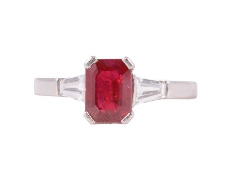 A ruby and diamond three stone ring, the emerald cut ruby, approximately 7.8x5.8x4mm, with a tapered baguette cut diamond eit