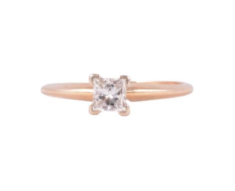 A diamond solitaire ring, the princess cut stone claw set in a yellow metal mount ring size K½, shank marked 14K and 18K, 0.4
