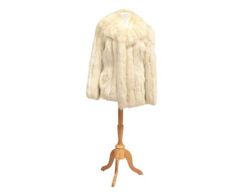 A light cream fur jacket with vertical pelts having suede detail between some, concealed pockets, collar with revers, full le