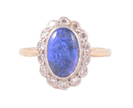 An opal and diamond cluster ring, the oval cabochon cut opal, approximately 11x7mm, collet set and surrounded by fourteen 8 c