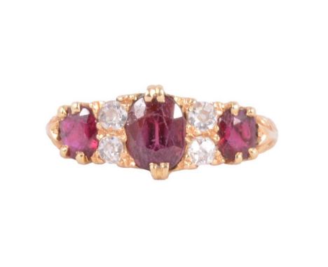 A ruby and diamond half hoop ring, three oval mixed cut rubies spaced by two pairs of old cut diamonds claw set in an 18 cara