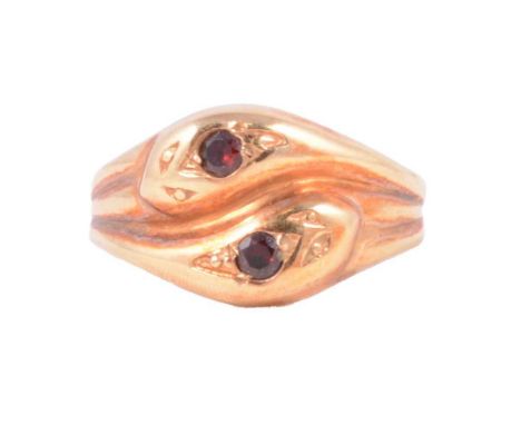 A 9 carat rose gold double snake head ring, each snake head claw set with a brilliant cut ruby, in a 9 carat rose gold twin s