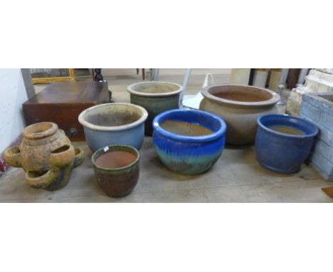 A small terracotta strawberry planter and six plant pots 