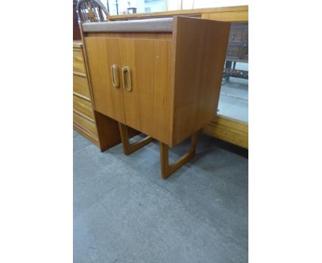 A teak two door cabinet on stand 