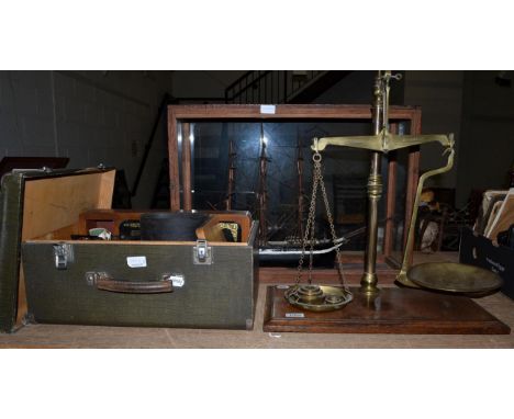 A scale model of a triple masted ship in a glazed case; a pair of brass scales with weights; and a Singer sewing machine in c