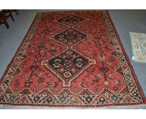 Kashgai carpet, South West Iran, the pale raspberry field with a column of hooked medallions enclosed by ivory borders, 290cm