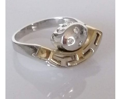 A cubic zirconia dress ring, the four central round brilliant cubic zirconias set in white metal, with a connecting yellow go