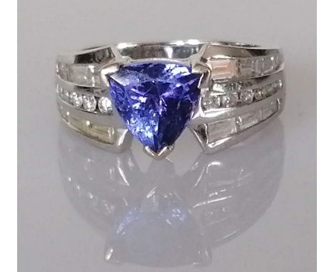 A tanzanite and diamond ring, the trilliant-cut tanzanite weighing an estimated 2.48 carats, diamond shoulders designed as a 