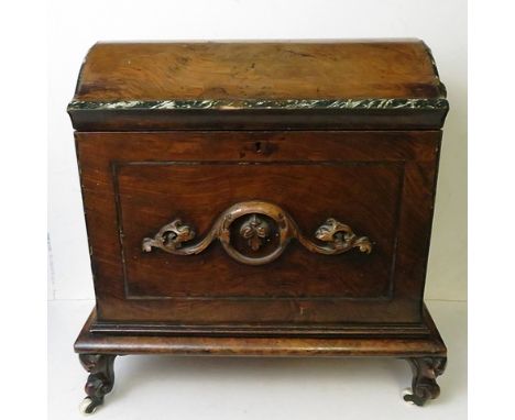 An early Victorian walnut music cabinet, the domed top having faux marbleized edges, scrolled leaf carving to front and sides