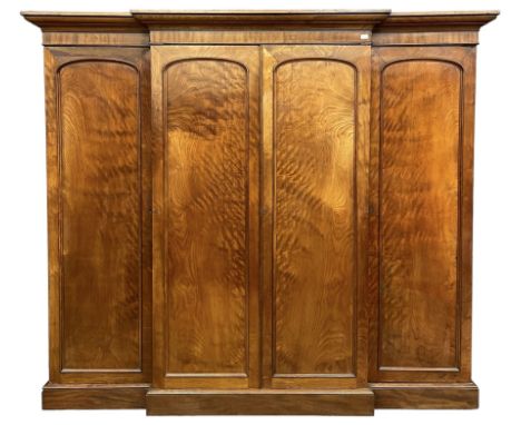 19th century figured mahogany quadruple breakfront press wardrobe, projecting cornice with banded frieze over arch panelled d