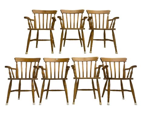 Set of seven beech farmhouse dining elbow chairs, stick back over saddle sat, raised on ring turned supports united by H-stre