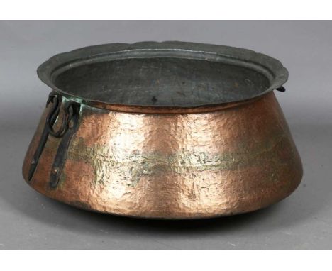 A large Eastern copper pan of low-bellied circular form, fitted with two loop handles, diameter 68cm.