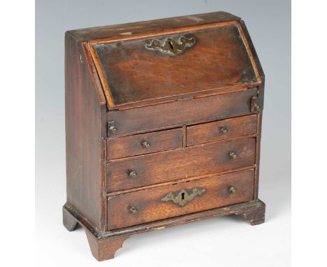 A late 18th century mahogany and softwood diminutive model of a bureau, all of the drawer-linings inscribed in black ink with
