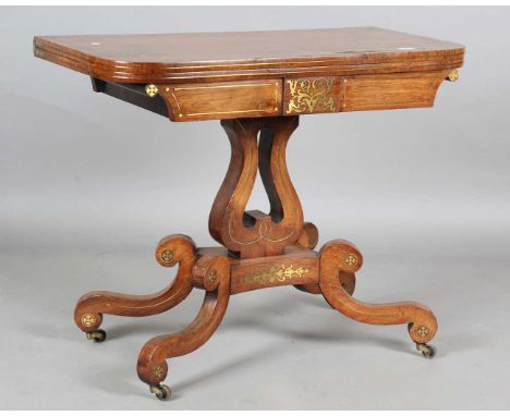 A Regency rosewood and brass inlaid fold-over card table, raised on a lyre support and sabre legs, height 72.5cm, width 90cm,
