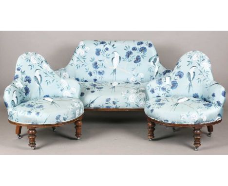 A late Victorian three-piece conversation settee and interfitting armchairs, upholstered in blue fabric painted with birds an