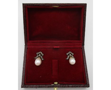 A pair of silver earrings with diamond set bow tops and pearl pendants, boxed 