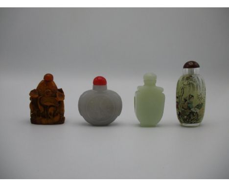 A collection of 20th century Chinese snuff bottles comprising a lavender jade model with central carved medallion, a celadon 