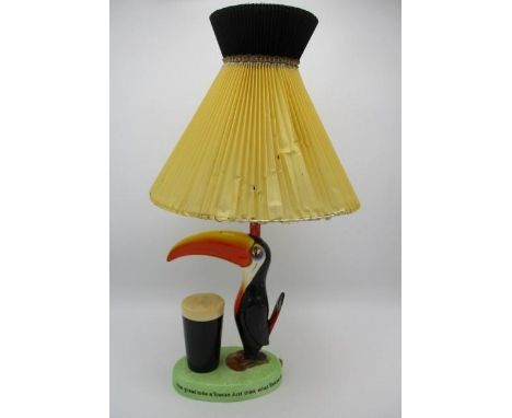 A Guinness advertising table lamp by Carlton Ware, fashioned as a toucan by a pint of Guinness, the base inscribed If he can 