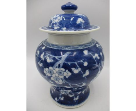 A late 19th century Chinese blue and white ginger jar of waisted form, with a domed cover, decorated with prunus blossom in b