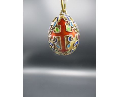 A yellow metal and enamel pendant in the form of an egg decorated with two crosses and scrolls 3/4"h 4.25 grams 