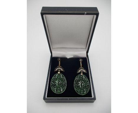 A pair of Asian 9ct gold and silver drop earrings, the carved and pierced jade panels decorated with scrolls, on a fan shaped