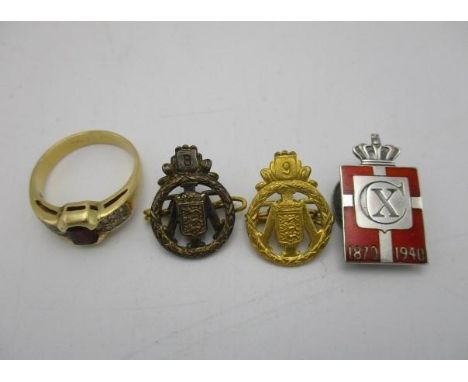 An 18ct gold ring set with a rectangular cut ruby flanked by fourteen diamonds, stamped 18k, 5.54g and two badges with three 