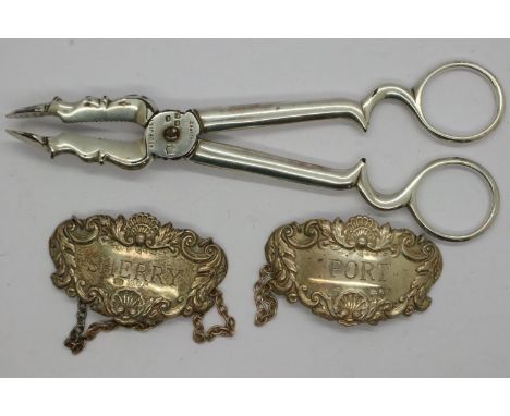 Hallmarked silver sherry and port bottle tags and a pair of continental white metal scissor form sugar tongs, labels 22g. UK 