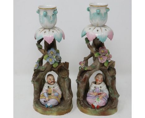 Pair of continental ceramic candle sticks in the form of writhen trees with Chinese figures, some minor losses to flowers, H: