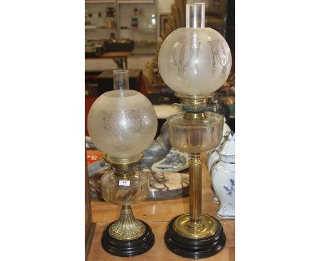 A Victorian brass oil lamp, having an acid etched glass shade and clear glass font, h.73cm; together with one other similar (