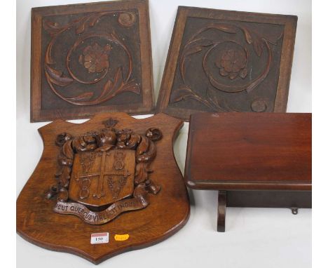 A carved oak coat of arms, 40 x 33cm; together with two carved walnut door panels; and a folding mahogany shelf (4)