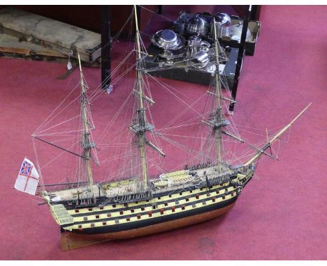 A wooden kit built model of HMS Victory, static display example hand painted in yellow and black with stained wooden decking,