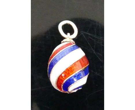 A Russian yellow metal and enamel egg shaped pendant in red, white and blue spiral bands, maker HW and with 56 gold mark, 5.1