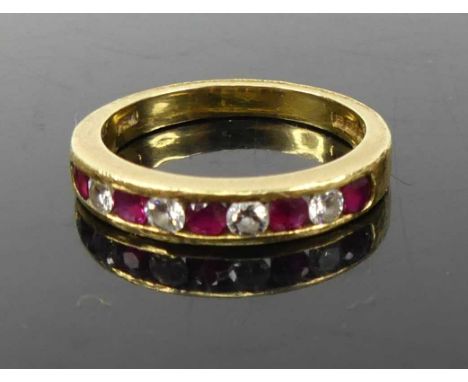 A contemporary 18ct gold ruby and diamond set half eternity ring, channel set with 9 alternating round cut stones, 3.9g, size