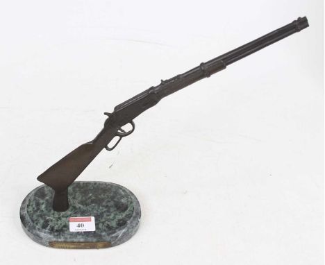 A bronzed metal model of a Winchester model 94 lever action rifle, mounted to polished hardstone plinth, height 30cm