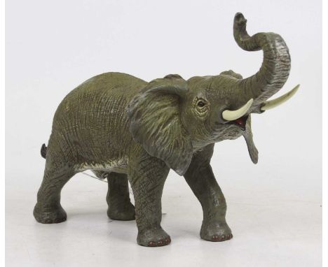A cold painted bronzed metal model of an elephant, shown standing with trunk raised, height 22cm