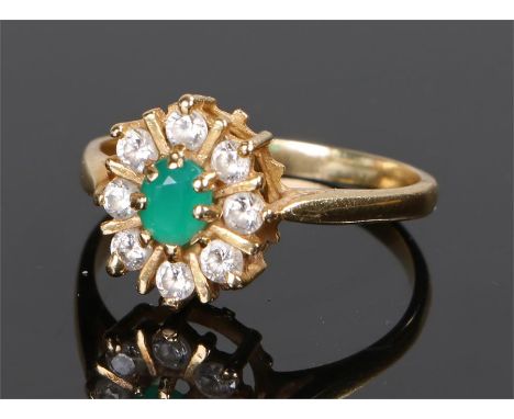 18 carat gold emerald and cubic zirconia set ring, the central emerald surrounded by a ring of eight cubic zirconia, ring siz