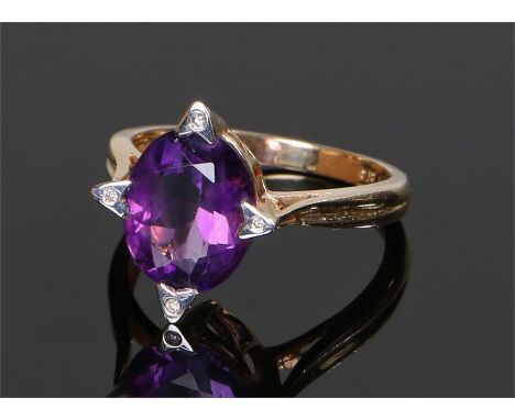 14 carat gold amethyst and diamond set ring with a central oval amethyst with four diamonds to the edge, ring size N