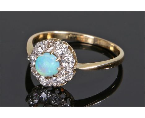 18 carat gold opal and diamond set ring, the central opal with a diamond surround, ring size O 1/2