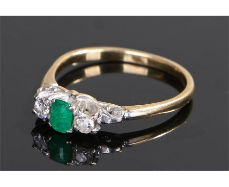 18 carat gold emerald and diamond set ring, the central, emerald cut, emerald with a round cut diamond to either side, ring s