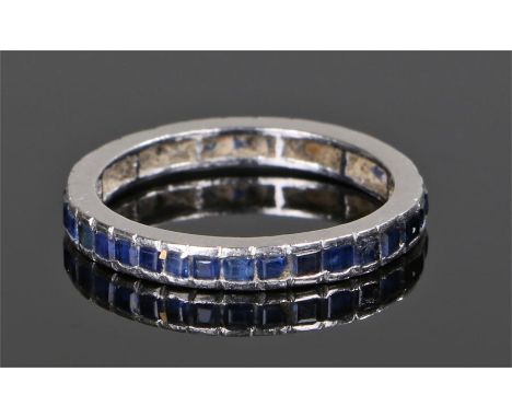 Sapphire eternity ring, the emerald cut sapphires set into white metal, ring size N 1/2 