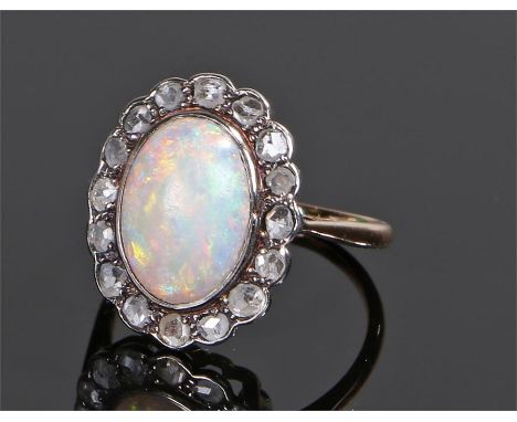 18 carat gold opal and diamond ring, the central oval cabochon opal with a diamond surround, ring size M 