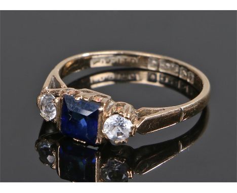 9 carat gold sapphire set ring, the central emerald cut sapphire flanked by cubic zirconia, ring size K