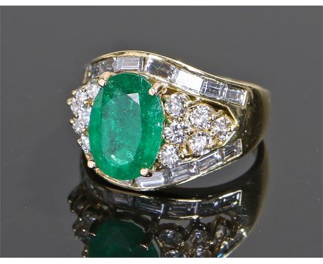 18 carat gold emerald and diamond set ring, the central emerald at approximately 2.7 carats with an emerald cut diamond and r