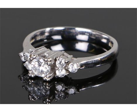 18 carat white gold and diamond ring, with a central round cut diamond flanked by three round cut diamonds to either shoulder