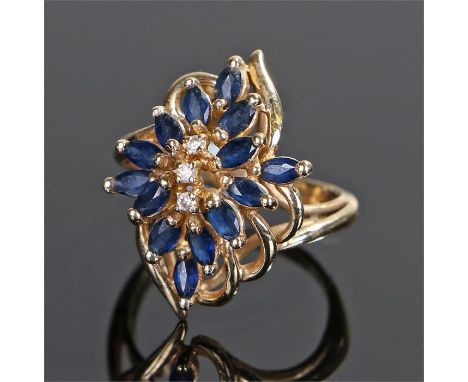 14 carat gold, sapphire and diamond set ring, in the form of a flower set with fifteen sapphires and three diamonds, ring siz